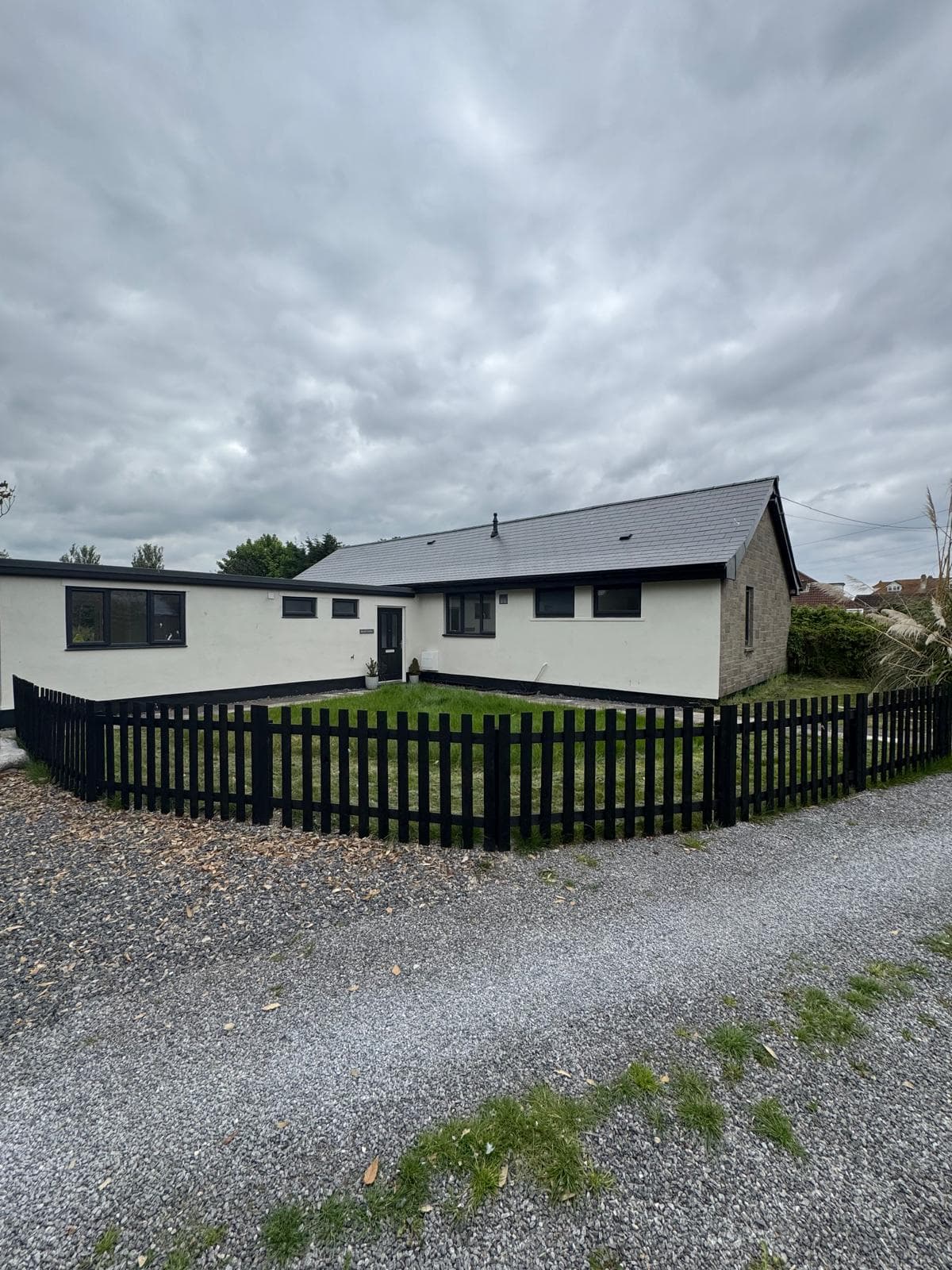Bungalow exterior painting with white walls and dark trim